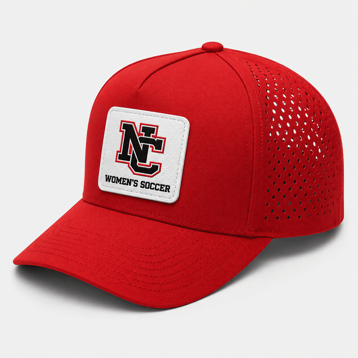 ChatGPT Image Aug 11 2026 12_58_57 PM | Greatest Of All Tees | GOAT Red baseball cap with perforated sides and a white badge on the front reading 'NC Women's Soccer' in black lettering.